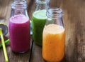 Fresh smoothies in bottles in three colors: green with spinach a