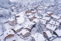 Fresh snow blankets rooftops and streets in an aerial view of a village in winter, A blanket of fresh snow covering rooftops and