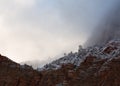 Fresh snow coats the trees atop the mountains of Zion national park while clouds drift across the land