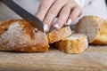 a fresh soft loaf of bread cut into pieces with a knife Royalty Free Stock Photo