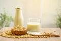 Fresh soybean seeds in brown wooden bowl, sugar in a spoon and two bottles of soy milk on the table,  under sunlight morning Royalty Free Stock Photo