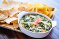 fresh spinach artichoke dip in a white bowl with tortilla chips Royalty Free Stock Photo