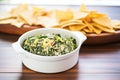 fresh spinach artichoke dip in a white bowl with tortilla chips Royalty Free Stock Photo