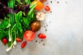 Fresh spinach,green onion, basil, herbs, dill and tomatoes on gray concrete background, selective focus. Top view. Toned