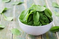 Fresh spinach leaves in bowl on rustic kitchen table Royalty Free Stock Photo