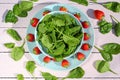 Fresh spinach salad with spinach and strawberries on wooden light pink table Royalty Free Stock Photo