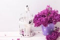 Fresh splendid lilac flowers in bucket and lantern with candl