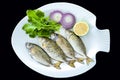 Fresh spotted spinefoot fish with rockets leaves served on white plate