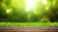 Fresh spring green grass with green bokeh and sunlight and wood floor. Beauty natural background Royalty Free Stock Photo