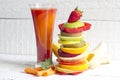 Fresh spring juice and pile of slice fruits and vegetables