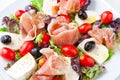 Fresh spring mix salad italian style with prosciutto and mozzarella,.seasoned with olive oil and black pepper.