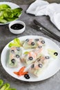 Fresh spring rolls in rice paper made from shrimp, olives and vegetables on a plate. Vertical view Royalty Free Stock Photo