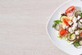 Fresh spring salad with cucumber, tomato, cheese and arugula isolated on a white plate Royalty Free Stock Photo