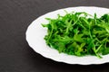 Fresh spring salad with rucola, in bowl on dark stone background Royalty Free Stock Photo