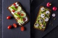 Fresh spring sandwich on a sliced gluten free sunflower bread. Red and green vegetables on black slate. Cucumber, chili and