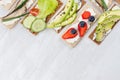 Fresh spring vitamine sandwiches of flat cereal rye dry crisps bread with vegetables, ripe fruits, fish preserves, cream cheese. Royalty Free Stock Photo