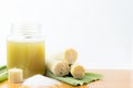 Fresh squeezed sugar cane juice in clear glass with cut pieces cane on white background Royalty Free Stock Photo