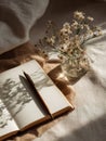 Fresh Start Idea With Clean Open Notebook and Pen on Beige Table Surrounded by Spring Shadows and Small Bouquet of Royalty Free Stock Photo