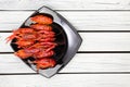 Fresh steamed crawfish on the black rectangular plate on the white wooden background