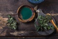 Fresh stinging nettle leaves on wooden table.Urtica dioica oil with spirulina powder, a healthy supplement to improve health