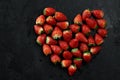 Fresh strawberries array heart shape on black background. Love concept. Valentine's Day Concept. Winter Concept.