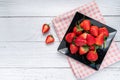 Fresh strawberries in black plate on white wood background.Top view with copy space. vegan food. healthy food concept Royalty Free Stock Photo