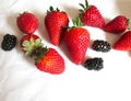 Fresh strawberries and blackberries on a white background