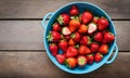 Fresh strawberries in a bowl on wooden table, top view Royalty Free Stock Photo