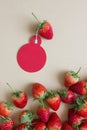 Fresh strawberries on a brown background and small red circle cards.