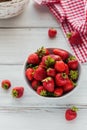 Fresh strawberries on ceramic bowl top view. Healthy food on white wooden table. Delicious, sweet, juicy and ripe berry background Royalty Free Stock Photo