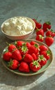 Fresh Strawberries on Ceramic Plate and Bowl of Whipped Cream on Concrete Surface Royalty Free Stock Photo
