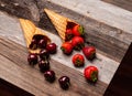 Fresh strawberries and cherries in waffle cones on wooden table Royalty Free Stock Photo