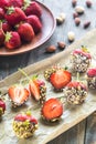 Fresh strawberries covered with dark chocolate and nuts Royalty Free Stock Photo