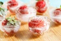 Fresh strawberries frozen in ice cubes, close-up. blurred background Royalty Free Stock Photo