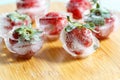 Fresh strawberries frozen in ice cubes, close-up. blurred background Royalty Free Stock Photo