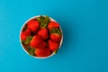 Fresh strawberries and green leaf in bowl isolated on blue background Royalty Free Stock Photo