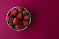 Fresh strawberries and green leaf in bowl isolated on red background Royalty Free Stock Photo