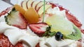 Fresh strawberries and other fruits neatly sliced and located on top of a homemade cake