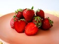fresh strawberries piled on a pink plate