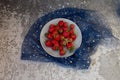 Fresh strawberries in a plate on a gray concrete table Royalty Free Stock Photo