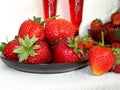 Fresh strawberries on a plate and juice in the cup