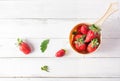 Fresh strawberries in strainer on white wood