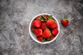 Fresh strawberries in a white bowl on dark background. vegan food. Top view with copy space. healthy food concept Royalty Free Stock Photo