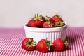 Fresh Strawberries in White Bowl on Red Gingham Tablecloth Royalty Free Stock Photo