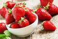 Fresh strawberries in a white porcelain bowl on wooden table in Royalty Free Stock Photo