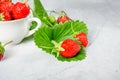 Fresh strawberries in a white porcelain bowl on wooden table in Royalty Free Stock Photo