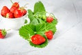 Fresh strawberries in a white porcelain bowl on wooden table in Royalty Free Stock Photo