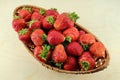 fresh strawberries in a wicker basket on a wooden surface Royalty Free Stock Photo