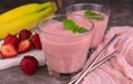 Fresh strawberry banana smoothie in glasses on a gray background. Royalty Free Stock Photo