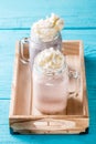 Fresh strawberry and blueberry milkshakes on blue table.